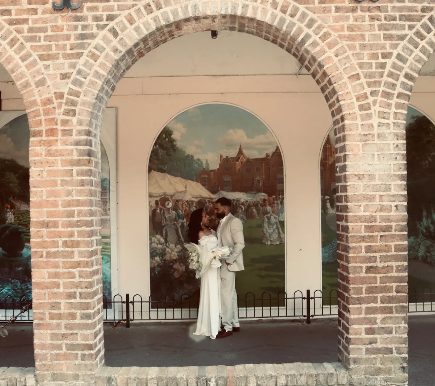 Fouad and Marina standing together beneath a brick archway