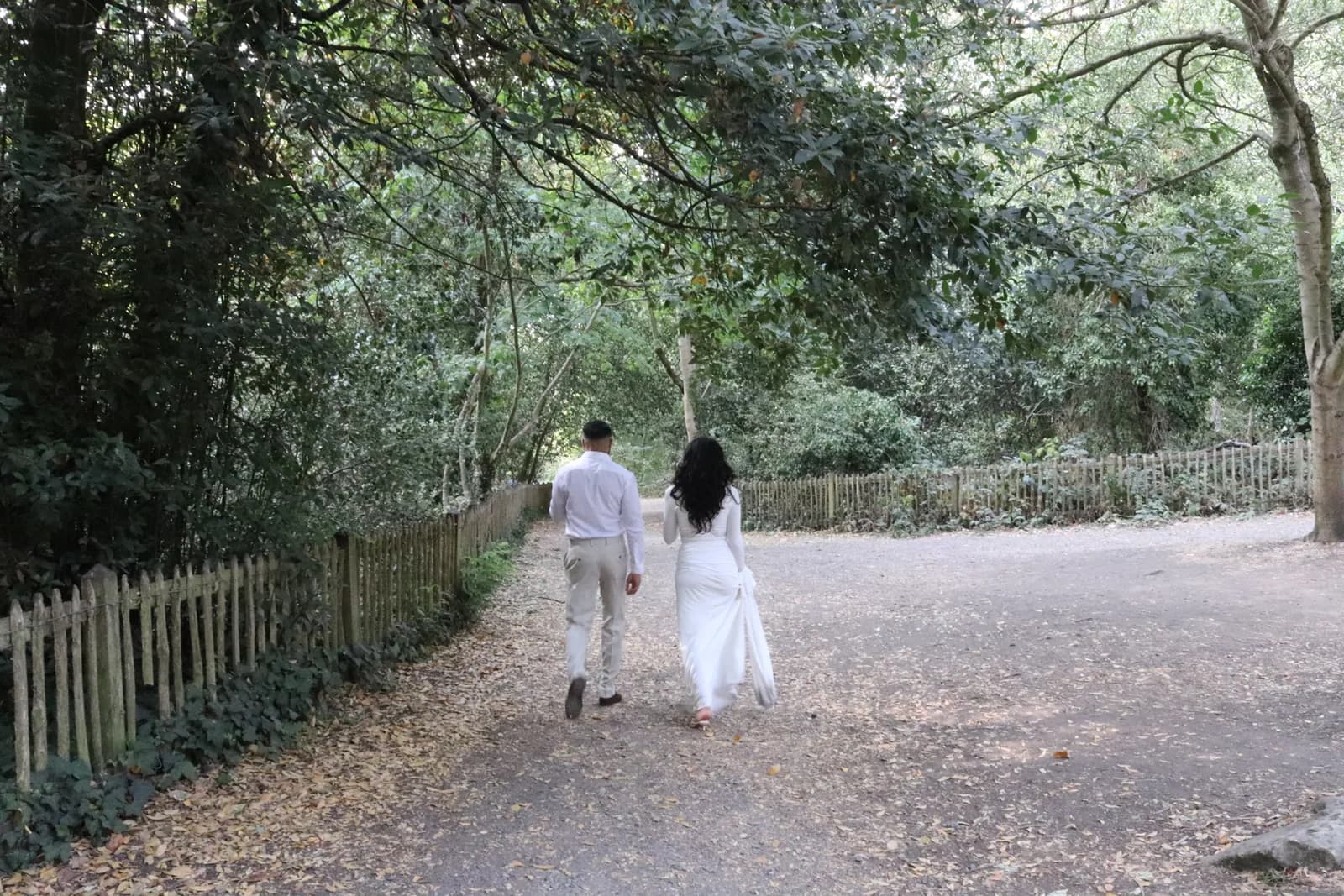 Fouad and Marina walking together along a tree-lined path